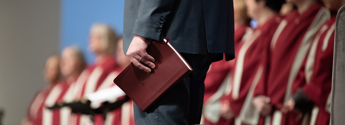 Close-up photo of Fair Haven Baptist Church Senior Pastor Andy Briggs holding a Bible by his side